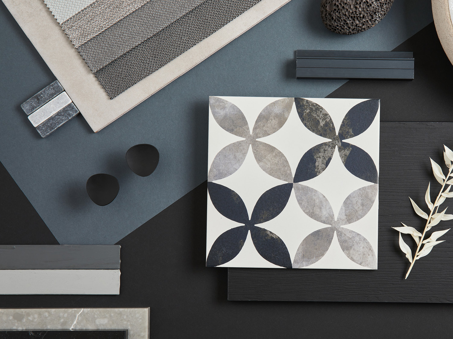 Flat lay of stylish architect moodboard composition with black, beige and grey samples of textile, paint, panels and tiles. Top view. Copy space. Template.